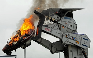 Illustration for article titled Behold The Car-Crushing Fury Of Robosaurus!
